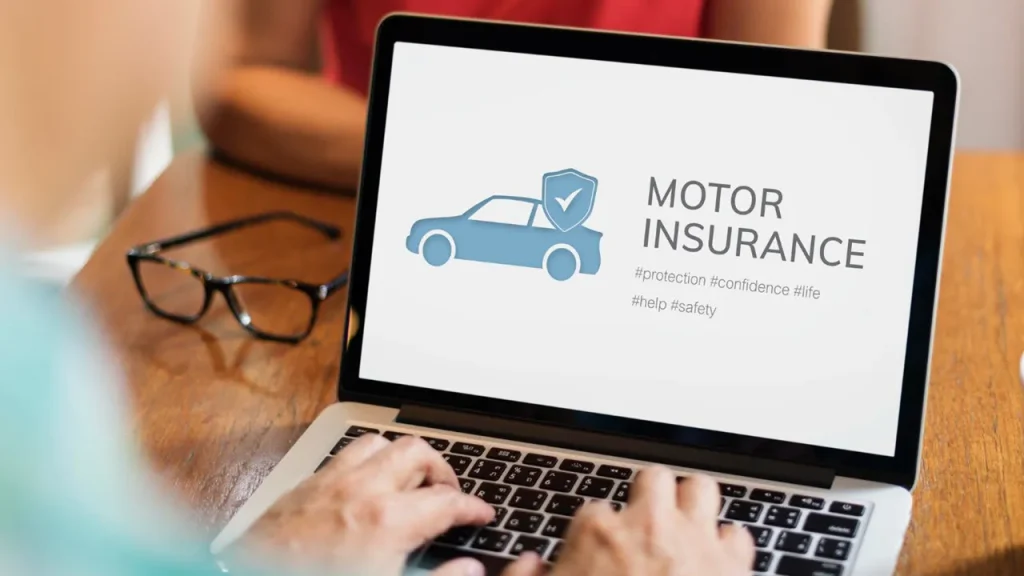 person typing on laptop with motor insurance image on screen