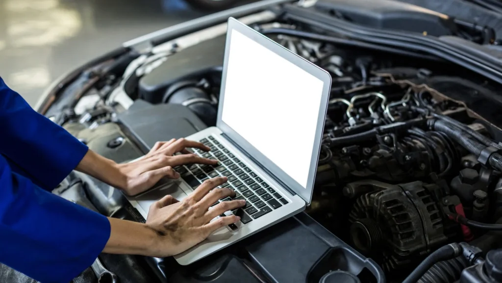 mechanic using computer to diagnose car problem
