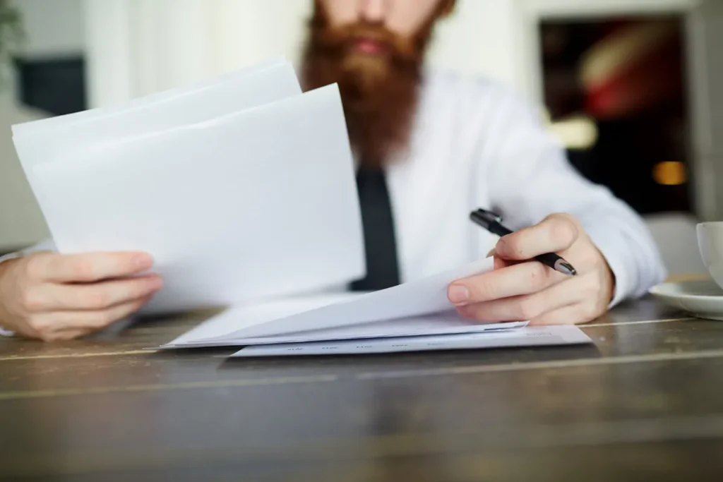 man reading business documents he has on a table in front of him